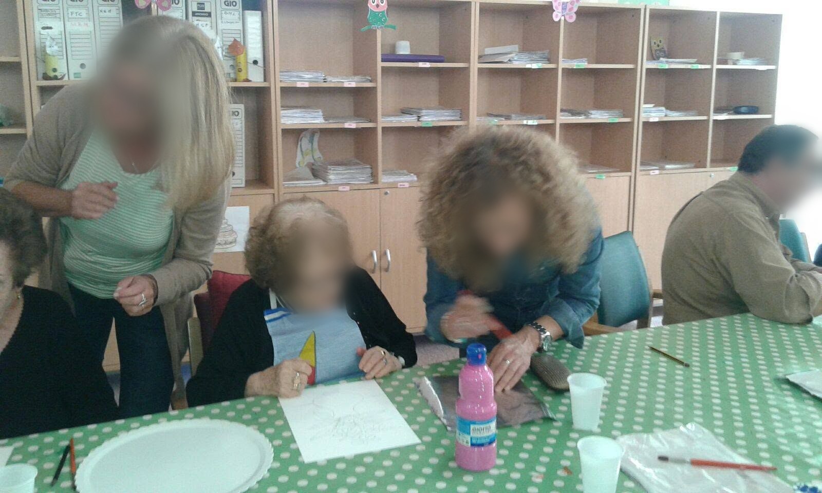 Profesoras ayudando a una usuaria del Centro de Día a pintar