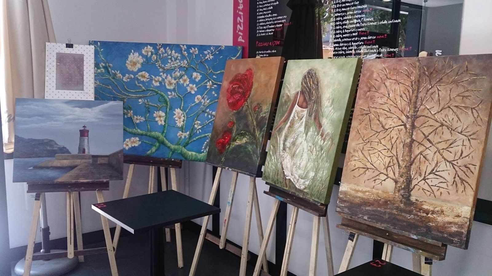 Exposición 2014: cuadros en caballetes con flores y árboles